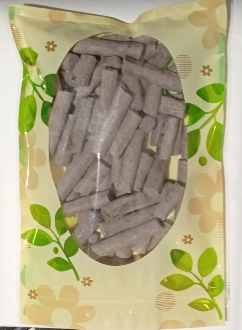 Pode incluir: Um saco pl&aacute;stico transparente com uma grande janela oval preenchida com numerosos objetos cil&iacute;ndricos cinzentos. O saco tem um fundo amarelo claro com padr&otilde;es florais e de folhas em verde e castanho.