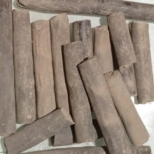 Pode incluir: Uma variedade de pe&ccedil;as de madeira cil&iacute;ndricas e desgastadas em tons de castanho e cinza. Algumas pe&ccedil;as s&atilde;o cortadas em &acirc;ngulo, enquanto outras t&ecirc;m uma forma mais natural e arredondada. A disposi&ccedil;&atilde;o sugere uma cole&ccedil;&atilde;o de materiais de artesanato r&uacute;sticos ou elementos decorativos.