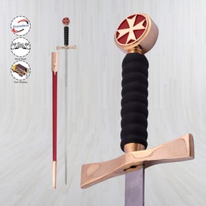 Puede incluir: Una espada decorativa con empuñadura y guarda doradas, empuñadura negra y pomo rojo y dorado con diseño de cruz. La espada se muestra con su vaina roja.