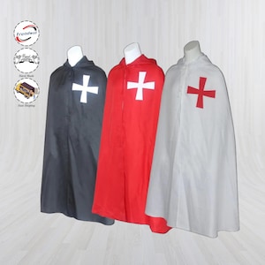 May include: Three hooded capes in black, red, and white, each with a large cross emblem. The capes are displayed on mannequins, highlighting their design. The crosses are white on the black and red capes, and red on the white cape.