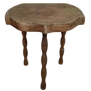 May include: A rustic wooden table with a scalloped top and three twisted legs.