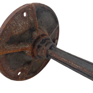 May include: A rusty metal base with a round plate and a long, cylindrical stem. The base is designed to be mounted to a wall or surface.