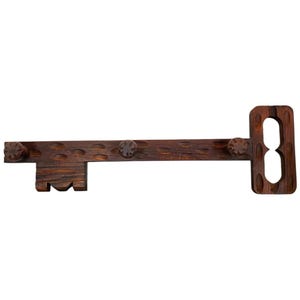 Peut inclure: Un crochet mural décoratif en forme de clé en bois brun foncé. La clé comporte trois boutons décoratifs et des détails sculptés. La poignée a deux cercles découpés. Un article de décoration rustique unique.