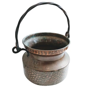 Peut inclure: Une marmite en cuivre martelé avec une poignée en fer tordu. La marmite a un aspect rustique et antique et est parfaite à des fins décoratives.