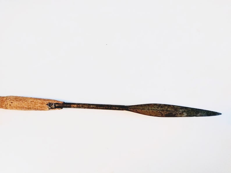 May include: A wooden-handled spear with a rusty metal blade. The spear is about 20 inches long.