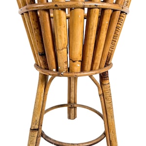 May include: A brown bamboo plant stand with a round top and three legs. The stand is made of natural bamboo and has a rustic look.