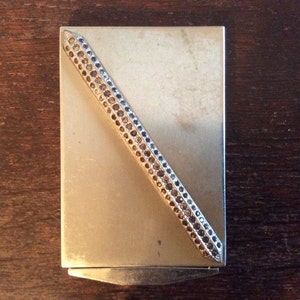 Contenitore per polvere in metallo argentato con zirconia compatta vintage, prodotto negli Stati Uniti, circa anni '60 / EVE