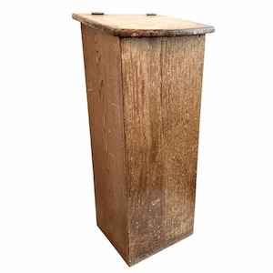 Puede incluir: Una caja de madera rectangular y alta con una tapa con bisagras. La caja está hecha de madera marrón claro con un acabado natural. La caja está vacía y tiene un diseño simple.