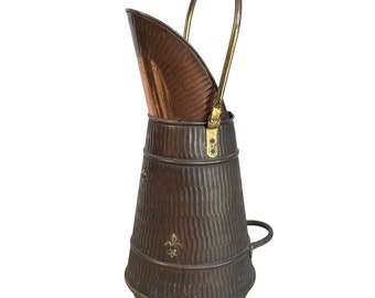 Può includere: Un secchio per carbone in rame e ottone con un design scanalato e un manico in ottone. Il secchio ha tre piedi e un design decorativo a giglio.