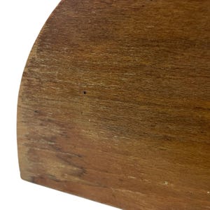 K&ouml;nnte beinhalten: Nahaufnahme eines Abschnitts einer Holzoberfl&auml;che. Das Holz hat eine warme braune Farbe mit sichtbarer Maserung und Textur. Die Kante des Holzes ist abgerundet, und die Oberfl&auml;che scheint abgenutzt zu sein.