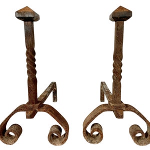 Peut inclure: Une paire de chenets de cheminée anciens avec un design en métal torsadé et des pieds enroulés. Les chenets sont en métal rouillé et ont un aspect rustique.