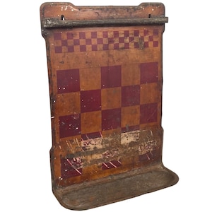 Peut inclure: Jeu de dames antique en bois avec un damier rouge et brun. Le plateau est monté sur un cadre métallique avec une étagère en dessous. Le plateau est usé et a un aspect rustique.