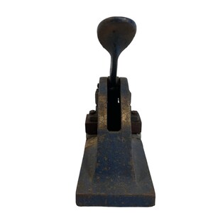 May include: A vintage blue and gold metal hand stamp with a lever.