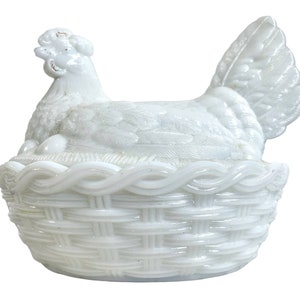 May include: White milk glass hen and chick dish. The hen is sitting in a woven basket with two chicks. The dish is in the shape of a hen and chicks.