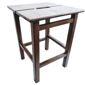 May include: A dark brown wooden stool with a simple design. The stool has a square top and four legs.
