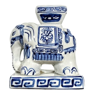May include: A blue and white ceramic elephant figurine with a decorative base. The elephant is standing on a square base with a blue and white design. The elephant has a blue and white design on its body and a blue and white design on its head.