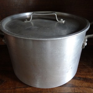 Peut inclure: Une casserole en aluminium argentée avec deux poignées et un couvercle. La casserole a une surface lisse et brillante.