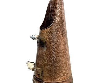 Può includere: Un secchio per carbone in rame martellato con due manici in ceramica bianca. Il secchio è un accessorio tradizionale per caminetti utilizzato per trasportare il carbone.