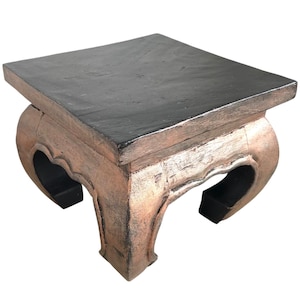 May include: A square wooden table with a black top and gold painted legs. The legs are curved and have a decorative design.