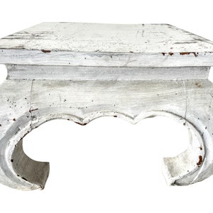 May include: White wooden side table with a distressed finish and curved legs. The table has a square top and a simple design.