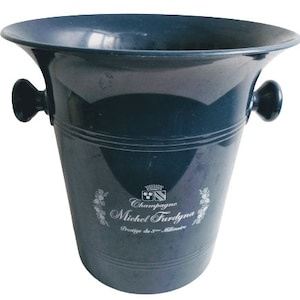 May include: A dark blue plastic champagne bucket with two handles. The bucket has a white logo that reads "Champagne Michel Ferdyné Prestige du Millénaire".