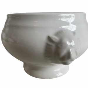 Puede incluir: Sopera de cerámica blanca con dos asas de cabeza de león.