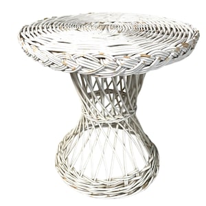 May include: White wicker stool with a round top and a woven base. The stool is made of natural materials and has a rustic, farmhouse style.