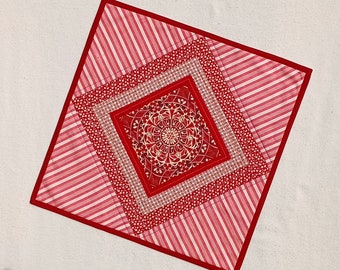 Red medallion table square, peppermint stripe candle mat, holiday red and white table centerpiece