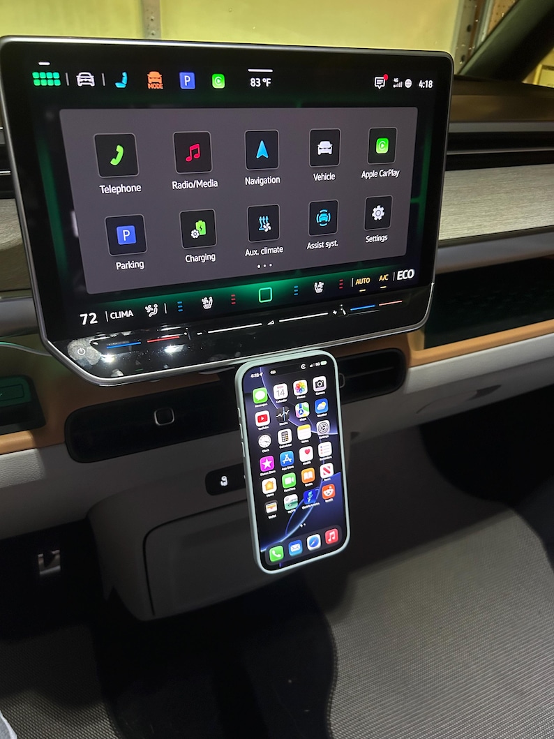 Puede incluir: Un tel&eacute;fono inteligente con una funda verde claro est&aacute; montado en un coche. La pantalla del tel&eacute;fono muestra iconos de aplicaciones. El salpicadero del coche tiene una gran pantalla t&aacute;ctil que muestra la navegaci&oacute;n y la informaci&oacute;n del veh&iacute;culo. La temperatura es de 28 grados Celsius.