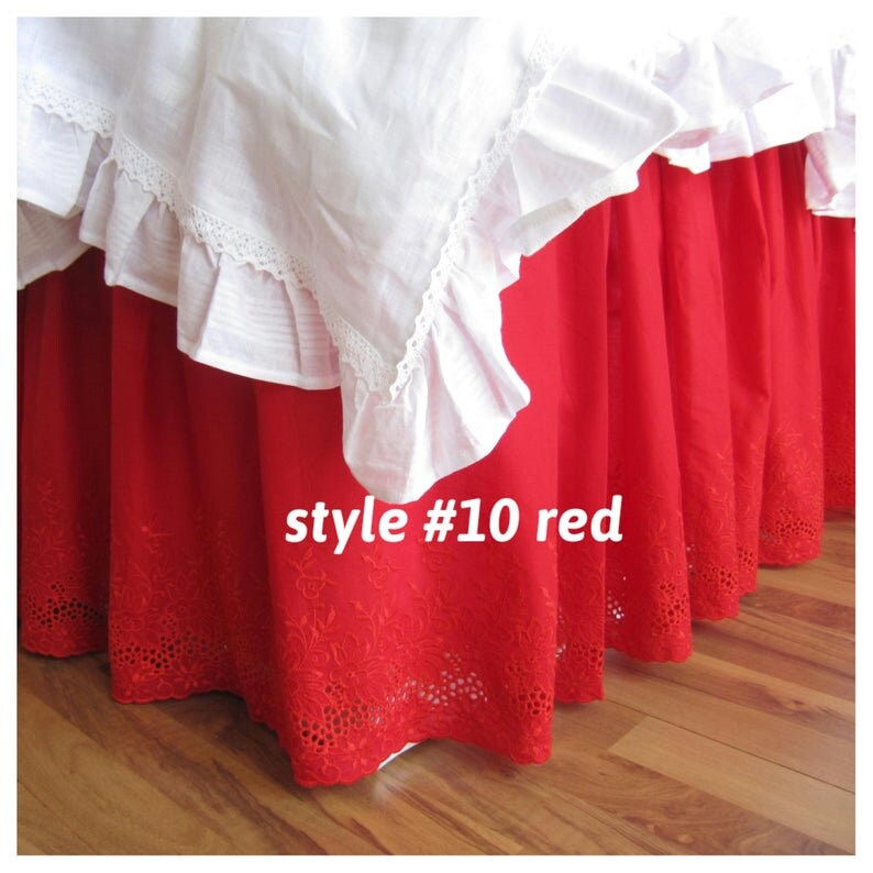 May include: Red bed skirt with white lace trim and embroidered details. The skirt is labeled "style #10 red".