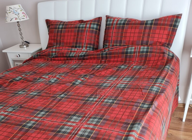 May include: Red and green plaid bedding with a white headboard. The bedding is made of a soft, comfortable fabric and has a classic plaid pattern.