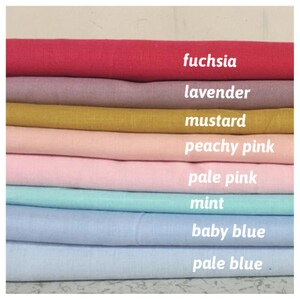 May include: A stack of eight fabric swatches in different colors, from top to bottom: fuchsia, lavender, mustard, peachy pink, pale pink, mint, baby blue, and pale blue.