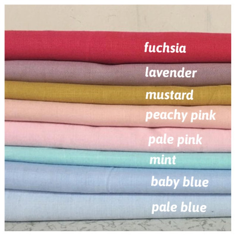 May include: A stack of eight fabric swatches in different colors, from top to bottom: fuchsia, lavender, mustard, peachy pink, pale pink, mint, baby blue, and pale blue.