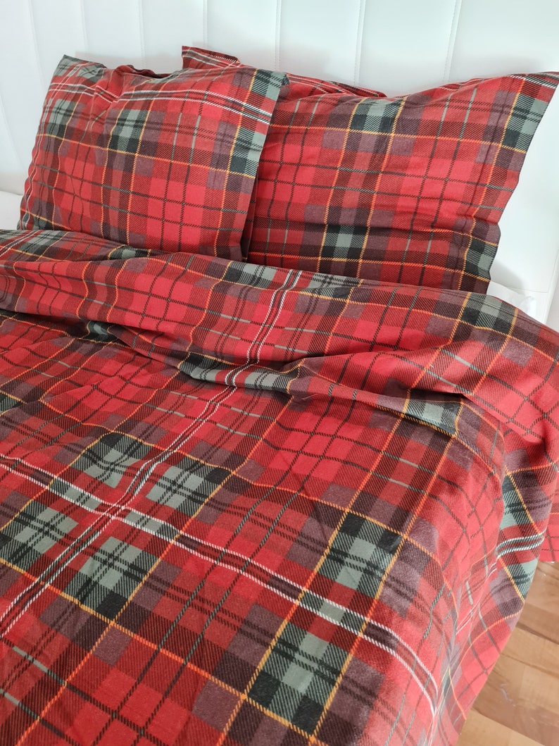 May include: Red, black, and yellow plaid bedding set with two matching pillowcases. The bedding is made of a soft, comfortable fabric and features a classic plaid pattern.