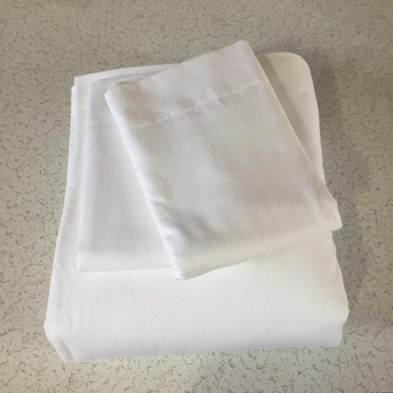 May include: Two white pillowcases, one folded on top of the other. The pillowcases are made of a soft, smooth fabric.