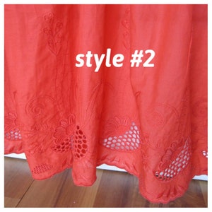 May include: Close-up of the bottom edge of a red cotton skirt with embroidered floral designs and cut-out details. The text "style #2" is visible in the center of the image.