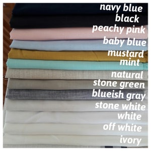 May include: A stack of 14 fabric swatches in various colors, including navy blue, black, peachy pink, baby blue, mustard, mint, natural, stone green, bluish gray, stone white, white, off white, and ivory.