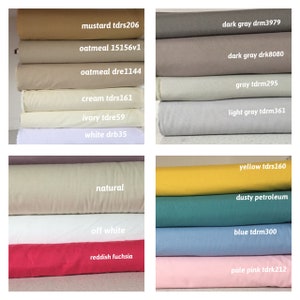 May include: A collection of fabric swatches in various colors, including mustard, oatmeal, cream, ivory, white, dark gray, light gray, yellow, dusty petroleum, blue, and pale pink. Each swatch has a color name and a code printed on it.
