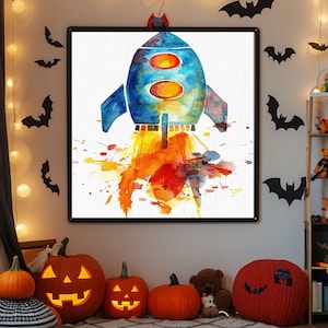 Peut inclure: Une peinture à l'aquarelle encadrée d'une fusée bleue et orange en train de décoller. L'œuvre est exposée sur un mur blanc décoré de découpes de chauves-souris noires et de guirlandes lumineuses. Des citrouilles et un tapis décoratif sont au premier plan.