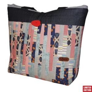 Può includere: Una borsa tote patchwork con parte superiore e manici in denim. La borsa presenta una varietà di tessuti rossi, blu e grigi, con una grande chiusura a bottone rossa. Una piccola etichetta in pelle è attaccata sul davanti. "Limited Edition" è stampato in basso a destra.