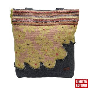 Könnte beinhalten: Handgefertigte Tragetasche mit floralem Design. Die Tasche hat ein gelbes Blumenmuster auf rosa Hintergrund, einen grauen Boden und eine gestreifte Oberseite. Die Tasche hat zwei graue Griffe und ein kleines braunes Lederetikett. Die Worte "LIMITED EDITION" stehen in einem roten Feld.