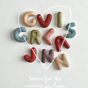 Puede incluir: Un juego de tres tazas de cerámica con un acabado mate moteado. Las tazas son de color crema, gris claro y gris oscuro. Cada taza tiene un diseño simple y minimalista.