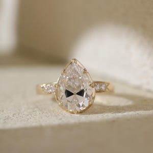 Anel solitário com diamante de lapidação pera, cultivado em laboratório, com fecho de botão, em ouro amarelo 18K. Ideal para presentear alguém especial.