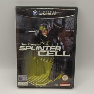 Op de afbeelding: Een Nintendo GameCube game case voor "Tom Clancy's Splinter Cell". De cover toont een man in tactische uitrusting die met een geweer richt, met de titel van het spel in grote, vette letters. De case heeft een "Must-have" sticker en een PAL Nintendo logo.