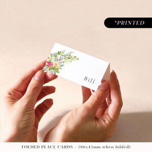 Tarjetas de lugar para bodas con arcos de flores de colores, tarjetas con nombres de invitados impresas con arcos florales, tarjetas de lugar con follaje botánico planas o dobladas