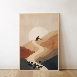 Könnte beinhalten: Ein gerahmter Kunstdruck zeigt eine minimalistische Landschaft mit einer Figur auf einem Hügel, einem Pfad und einer Schafherde. Die Farbpalette umfasst warme Erdtöne mit einer großen Sonne im Hintergrund. Das Kunstwerk befindet sich in einem Holzrahmen.