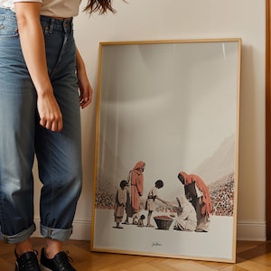Op de afbeelding: Een ingelijste kunstdruk met een scène van figuren in gewaden die rond een mand zijn verzameld. Het kunstwerk heeft een neutraal kleurenpalet met vleugjes rood en bruin. De lijst is licht van kleur.