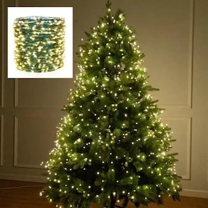 May include: A lit Christmas tree with warm white lights. A bundle of string lights is in the upper left corner. The tree is green and full, with many small lights throughout the branches, creating a festive holiday display.