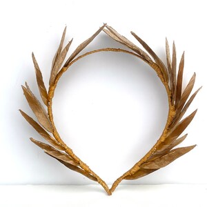 May include: A gold-colored laurel wreath headband made of woven leaves.