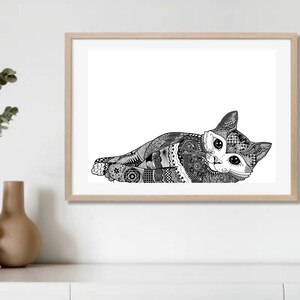 May include: A framed black and white art print of a cat lying down. The cat is intricately patterned with various designs. The artwork is displayed in a light-colored wooden frame, set against a white wall. Decorative vases and greenery are in the foreground.